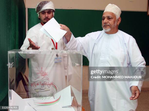 An Omani man casts his vote at a polling station in Muscat, on October 15 as Omanis elect the powerless Majlis Al-Shura consultative council, which...