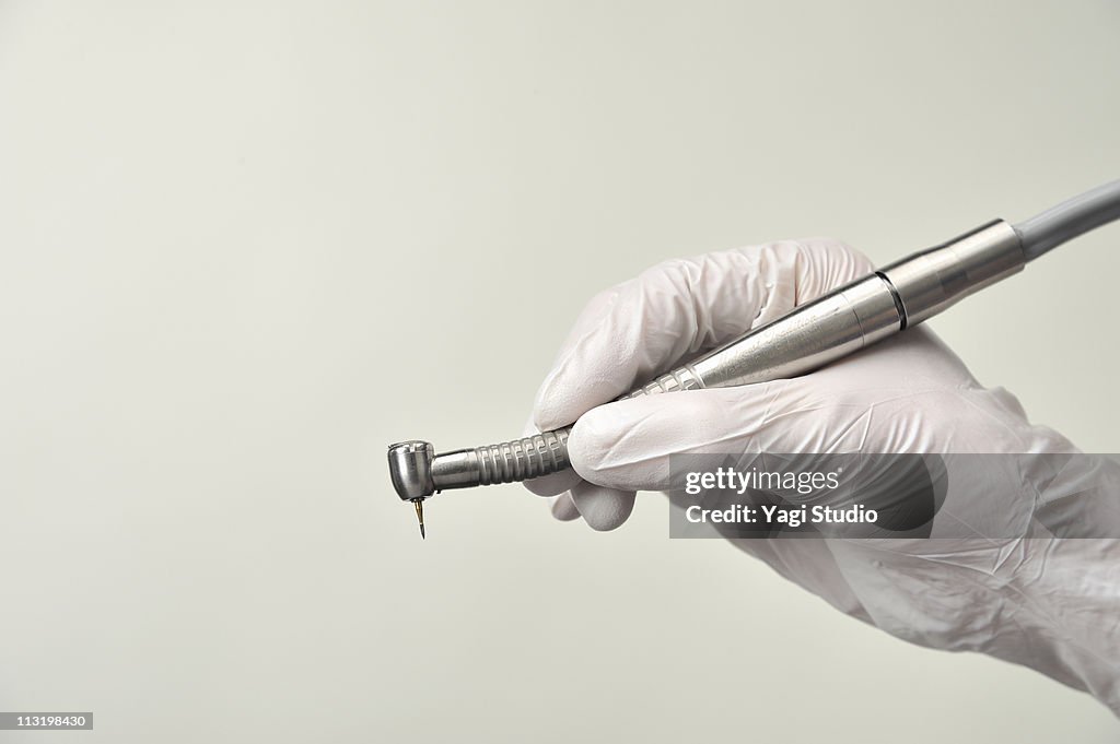 The hand which has a dentist's instrument