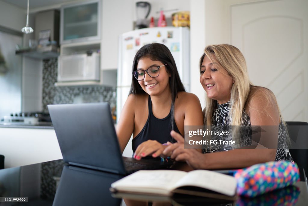 Mère et fille utilisant l'ordinateur portatif à la maison