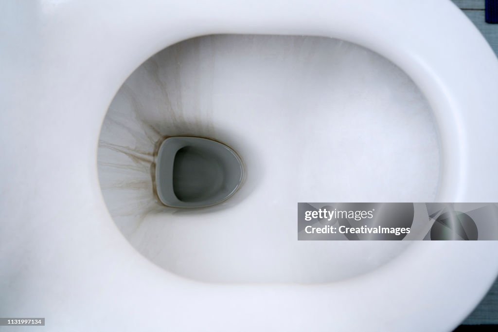 Dirty toilet bowl with limescale stain