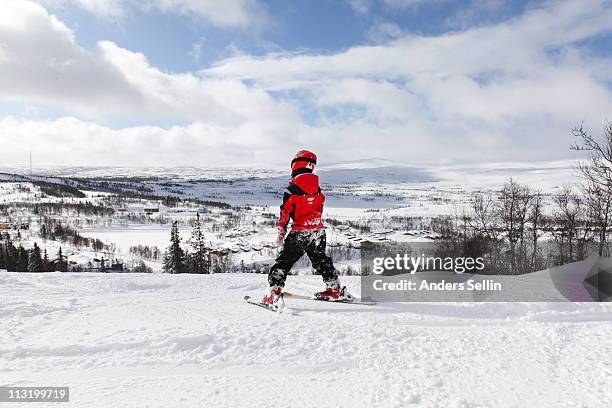 young boy skiing slalom downhill in sunshine - downhill stockfoto's en -beelden