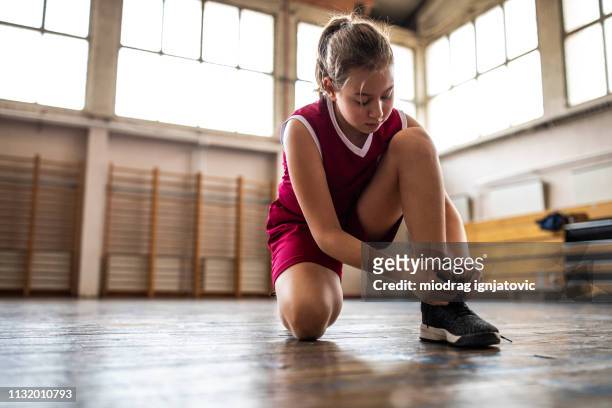 jugador de baloncesto adolescente atar shoelace - basketball shoe fotografías e imágenes de stock