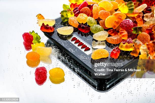 diet jelly sweet on a black balance with hearts display (weingummi ) - schmecken stock pictures, royalty-free photos & images