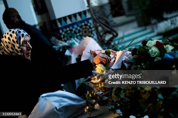 Muslim woman lays flower during a tribute ceremony, at the Grande Mosquee de Paris in Paris on March 22 for the victims of the twin mosques massacres...
