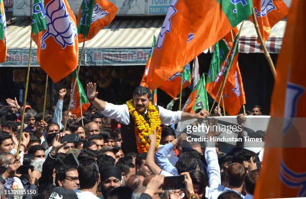 Union Minister and BJP Candidate Jugal Kishore Sharma waves at supporters as he arrives to file his nomination for Jammu-Poonch constituency ahead of...