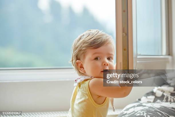 little girl near window - open romania imagens e fotografias de stock