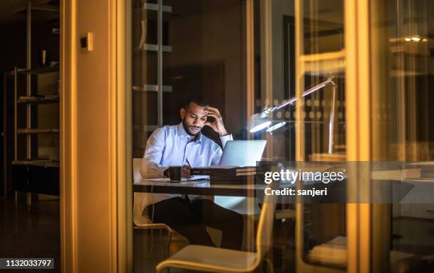 homme d'affaires surtravaillé travaillant tard dans le bureau - businessman busy photos et images de collection