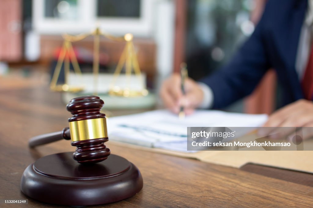 Cropped Hands Of Judge By Gravel At Table