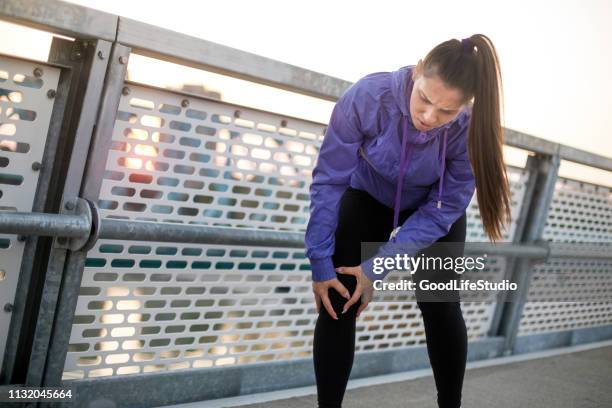 young woman with injured knee - injured knee stock pictures, royalty-free photos & images