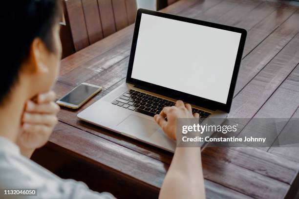 man using laptop on wooden table - modelos homens imagens e fotografias de stock