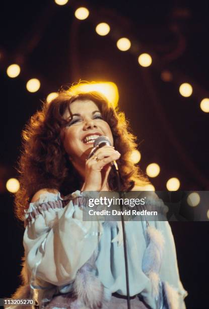 Jody Miller, U.S. Country music singer, singing into a microphone during a live concert performance, circa 1970.