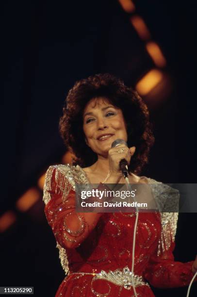 Loretta Lynn, U.S. Country music singer-songwriter, singing into a microphone during a live concert performance at the International Festival of...