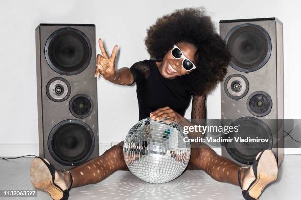 woman in black dress leaning on disco ball and gesturing - teen soles stock pictures, royalty-free photos & images