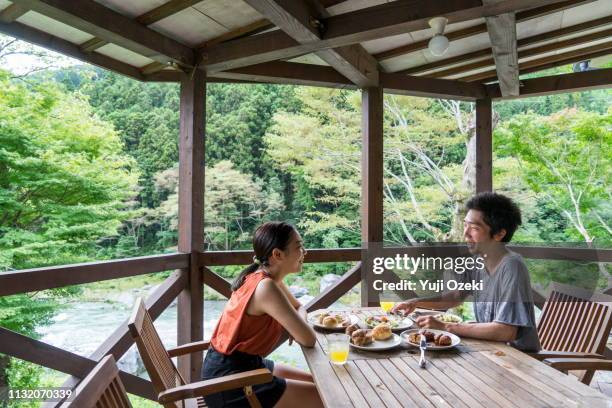 a young couple having breakfast happily in the veranda of the cottage. - butlins fotografías e imágenes de stock