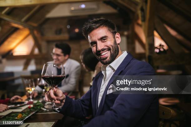 bel uomo d'affari che tiene un bicchiere di vino rosso - stud foto e immagini stock