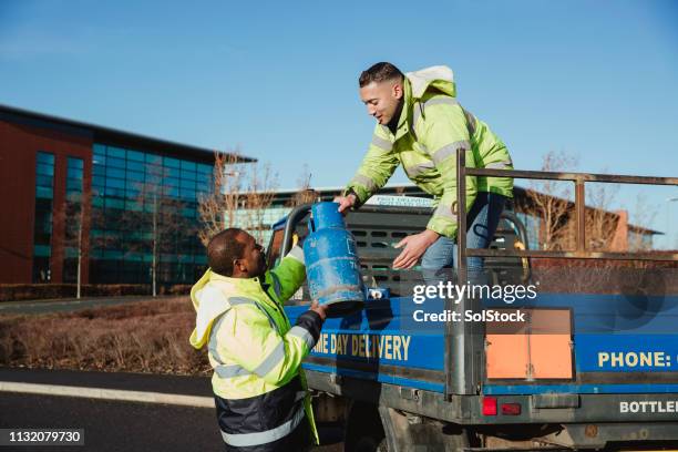 arbeiter sperrten einen lastwagen mit gaskanister - gas cylinder stock-fotos und bilder