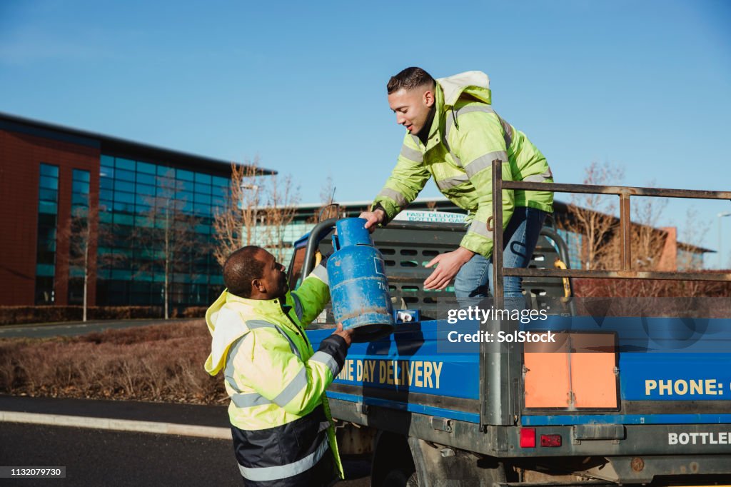 Workers Loading a Truck with Gas Canisters