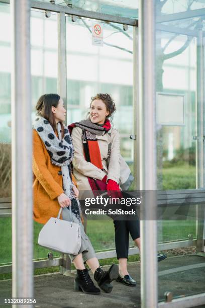 female coworkers at the bus stop - waiting bus stock pictures, royalty-free photos & images