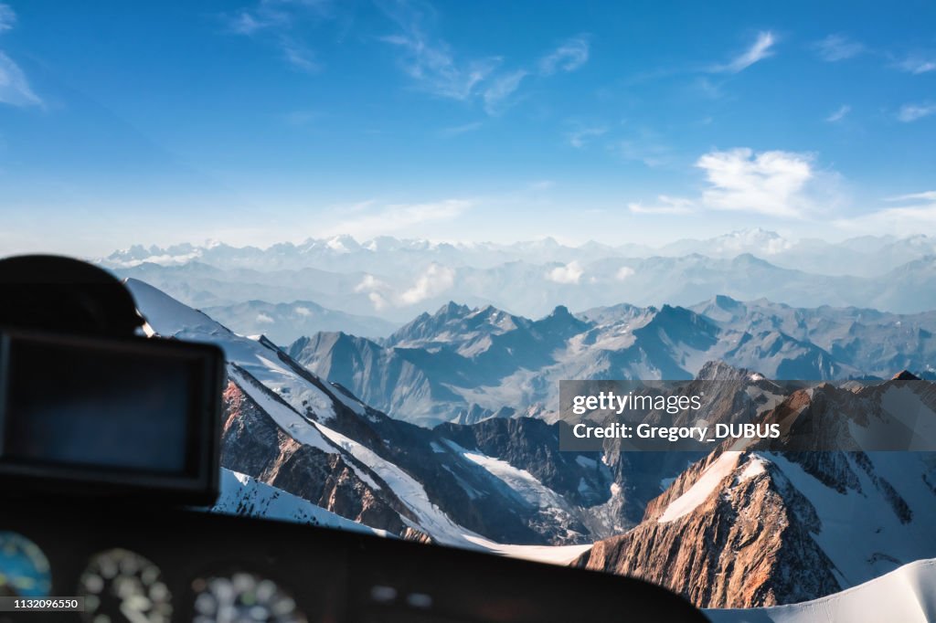 Looking at Mont Blanc massif in french Alps mountains through helicopter cockpit window aerial view