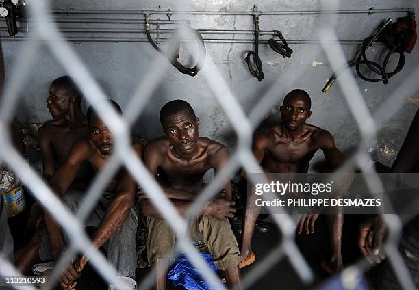 Men arrested by pro-Ouattara armed militia and suspected of looting wait in jail in a district of Abidjan on April 15, 2011. Ivory Coast's slow...