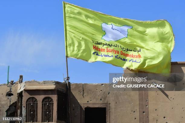Picture taken on March 23, 2019 shows the US-backed Syrian Democratic Forces' flag atop a building in the Islamic State group's last bastion in the...