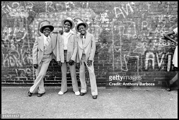 Portrait of a trio of smiling, well-dressed young boys as they pose on a Harlem street, New York, New York, 1975.