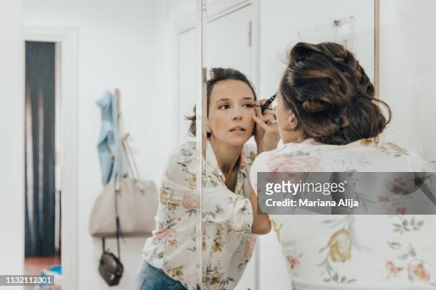 woman applying makeup before leaving - makeup woman stock pictures, royalty-free photos & images