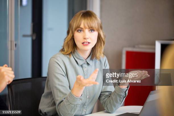 businesswoman sharing ideas with colleagues - esprimere a gesti foto e immagini stock