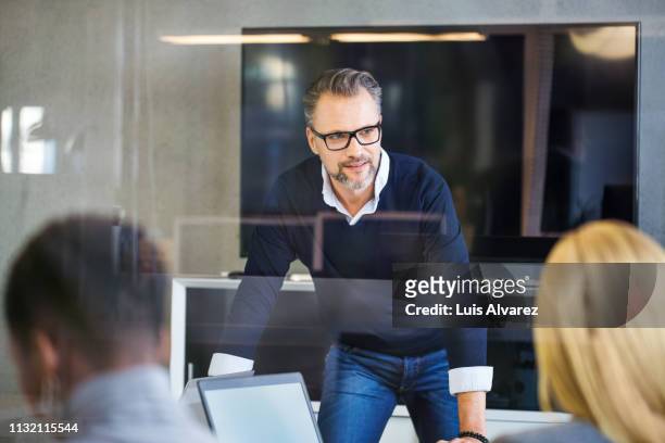 mature businessman having discussion in meeting room - business blue stock-fotos und bilder