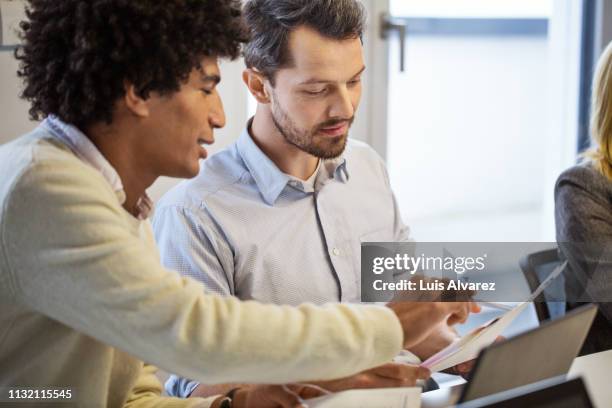 business people discussing over document in office - yellow shirt stock pictures, royalty-free photos & images