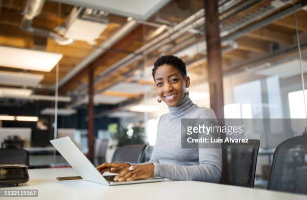 portrait of mid adult woman using laptop - mock turtleneck foto e immagini stock