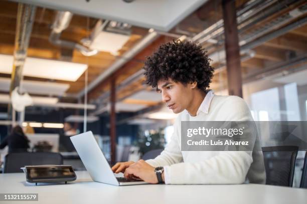 young businessman using laptop in office - man laptop stock pictures, royalty-free photos & images