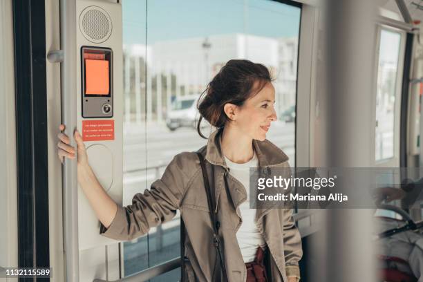 woman talking on the cell phone at tram - trench stock photos et images de collection