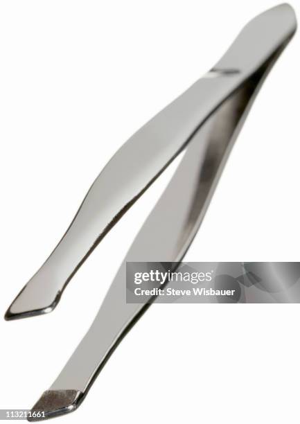 a pair of silver metallic tweezers - eyebrow tweezers stock pictures, royalty-free photos & images
