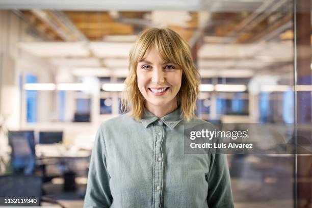 beautiful businesswoman standing in modern office. - face on woman stock-fotos und bilder