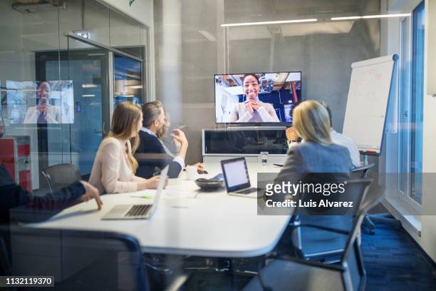 businesswoman having video conference meeting with team - global communications stock-fotos und bilder