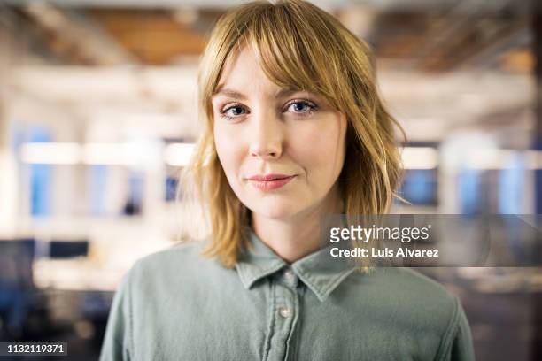 portrait of young businesswoman in office - portretfoto stockfoto's en -beelden