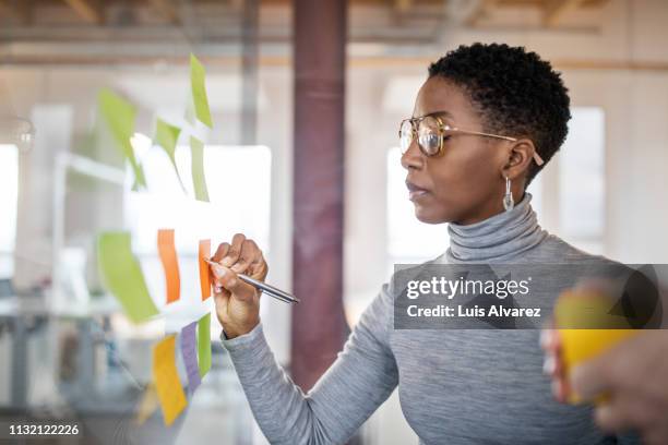 business people brainstorming using sticky notes - camera focus fotografías e imágenes de stock