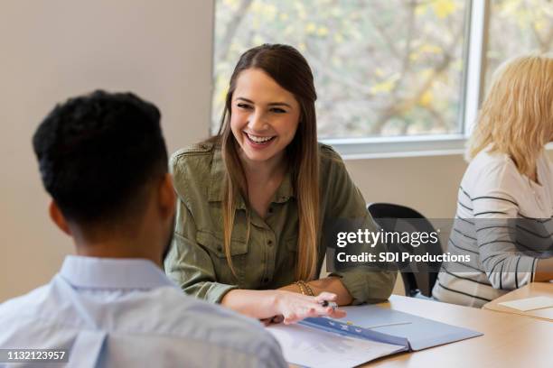 cheerful young businesswoman explains ideas to coworker - conference table stock pictures, royalty-free photos & images