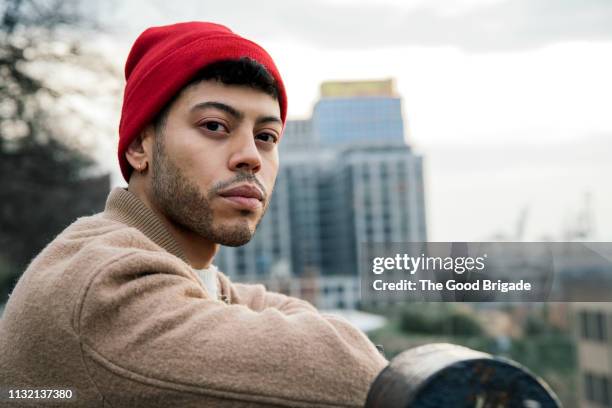 portrait of young man against city skyline - serious photos et images de collection