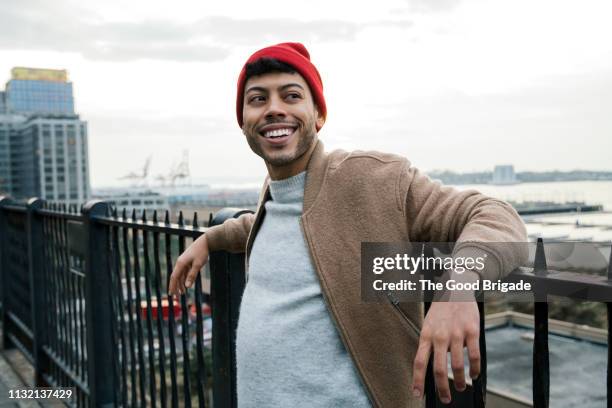 portrait of hipster man wearing red knit hat - leben in der stadt stock-fotos und bilder