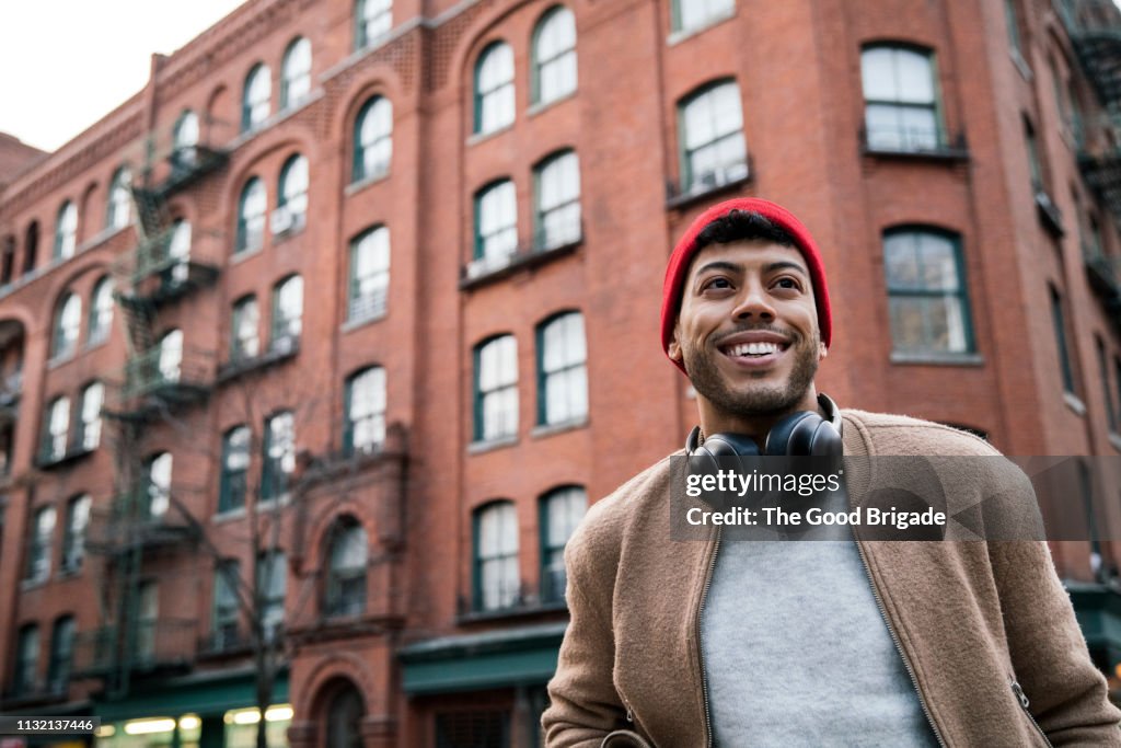 Low angle view of young man standing on city street