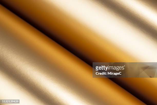 rolled up golden colored texture - shiny foil stock pictures, royalty-free photos & images