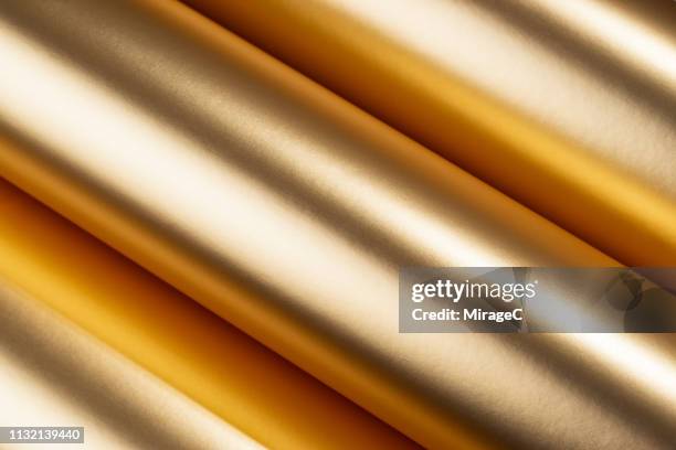 rolled up golden colored texture - foil material stock pictures, royalty-free photos & images