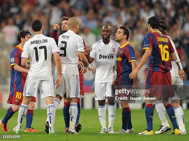 Xavi Hernandez and Gerard Pique of Barcelona argue with Alvaro Arbeloa , Pepe and Lassana Diarra of Real Madrid during the UEFA Champions League Semi...