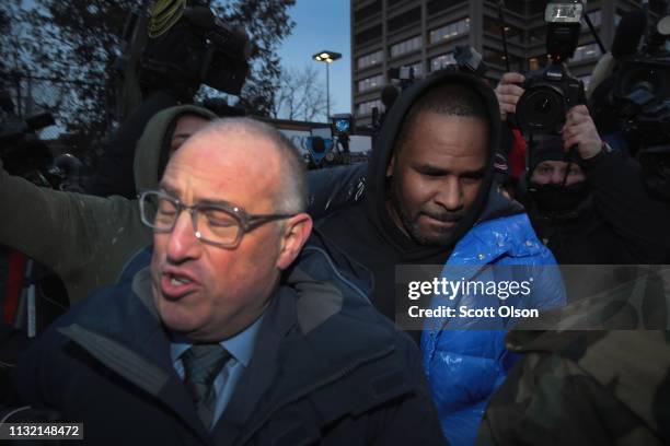 Singer R. Kelly and his attorney Steve Greenberg fight their way through photographers outside of the Cook County jail after posting $100 thousand...