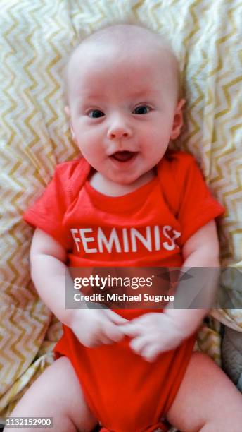 Smiling newborn baby in clever onesie.