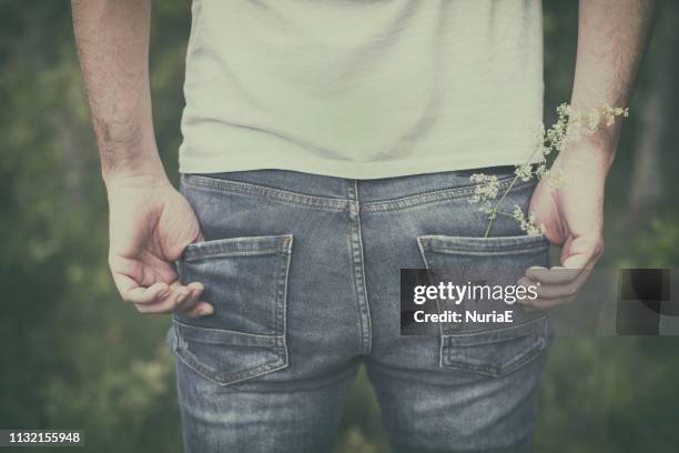 close-up of a man with his hands in his pockets wearing jeans - male buttocks stockfoto's en -beelden