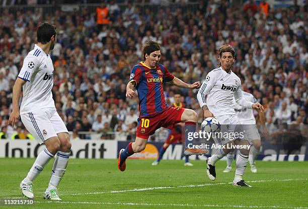 Lionel Messi of Barcelona beat Sergio Ramos of Real Madrid to score the opening goal during the UEFA Champions League Semi Final first leg match...