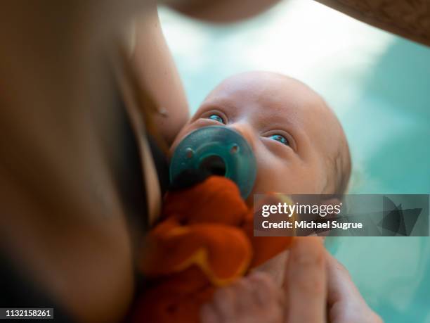 A newborn baby takes a bath.